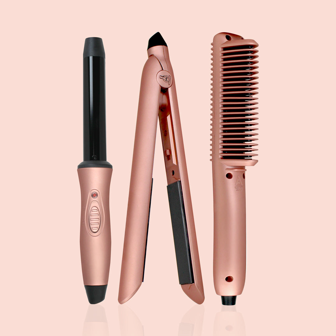 Set of rose gold hair styling tools on a light pink background